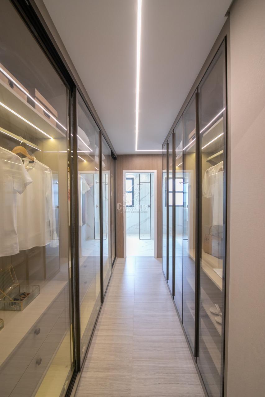 Closet do apartamento decorado com armários envidraçados e iluminação em LED