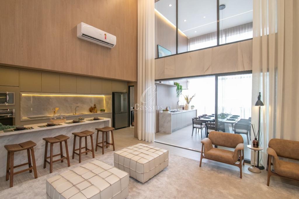 Living do apartamento decorado/modelo com pé-direito duplo, cozinha integrada e banquetas