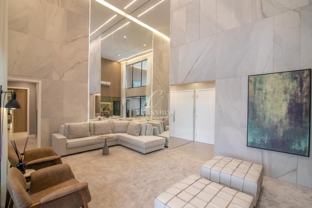 Sala de estar do apartamento decorado com painel de mármore, espelhos e sofá amplo