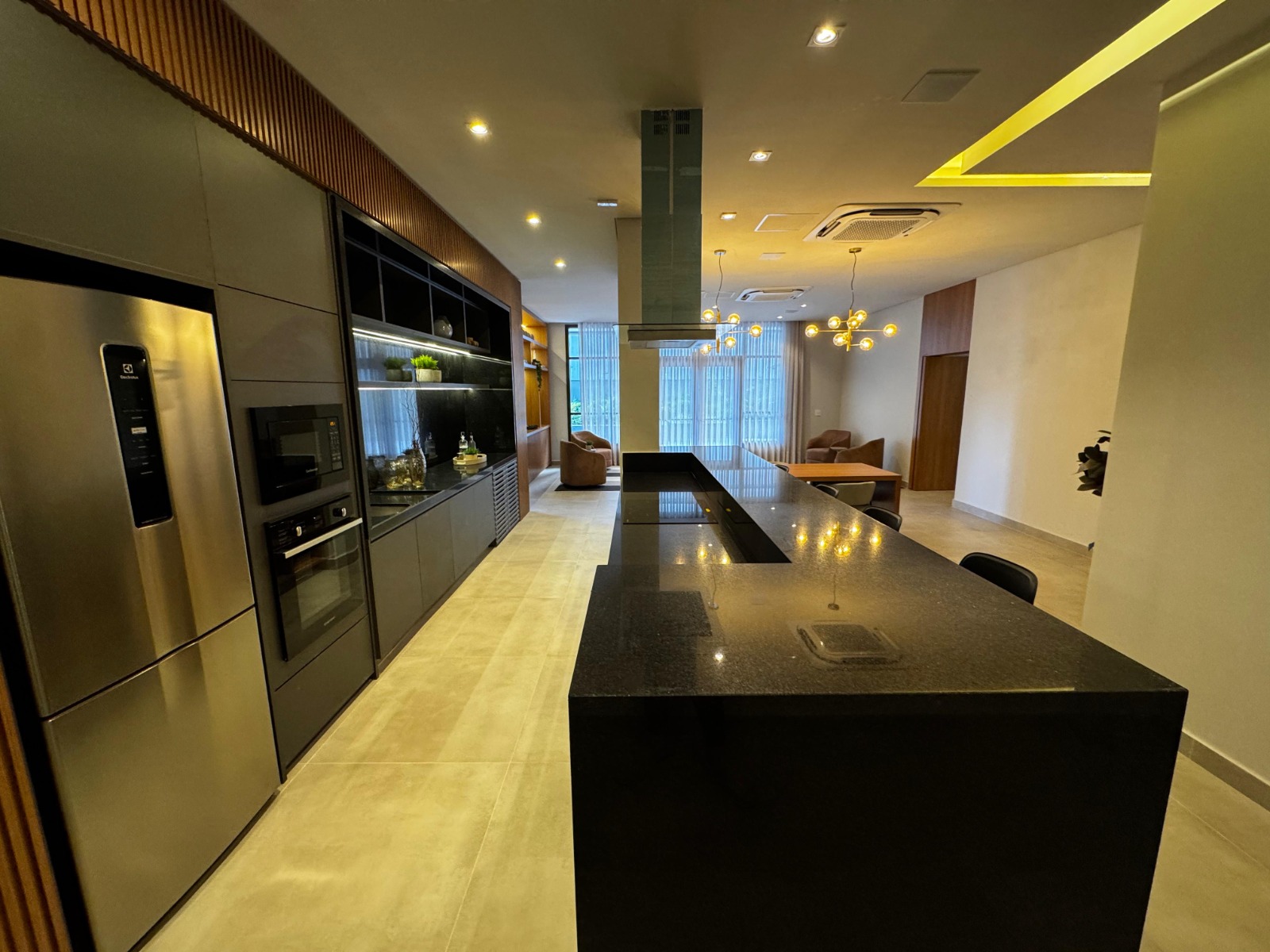 Espaço gourmet do condomínio com ilha, cooktop e forno